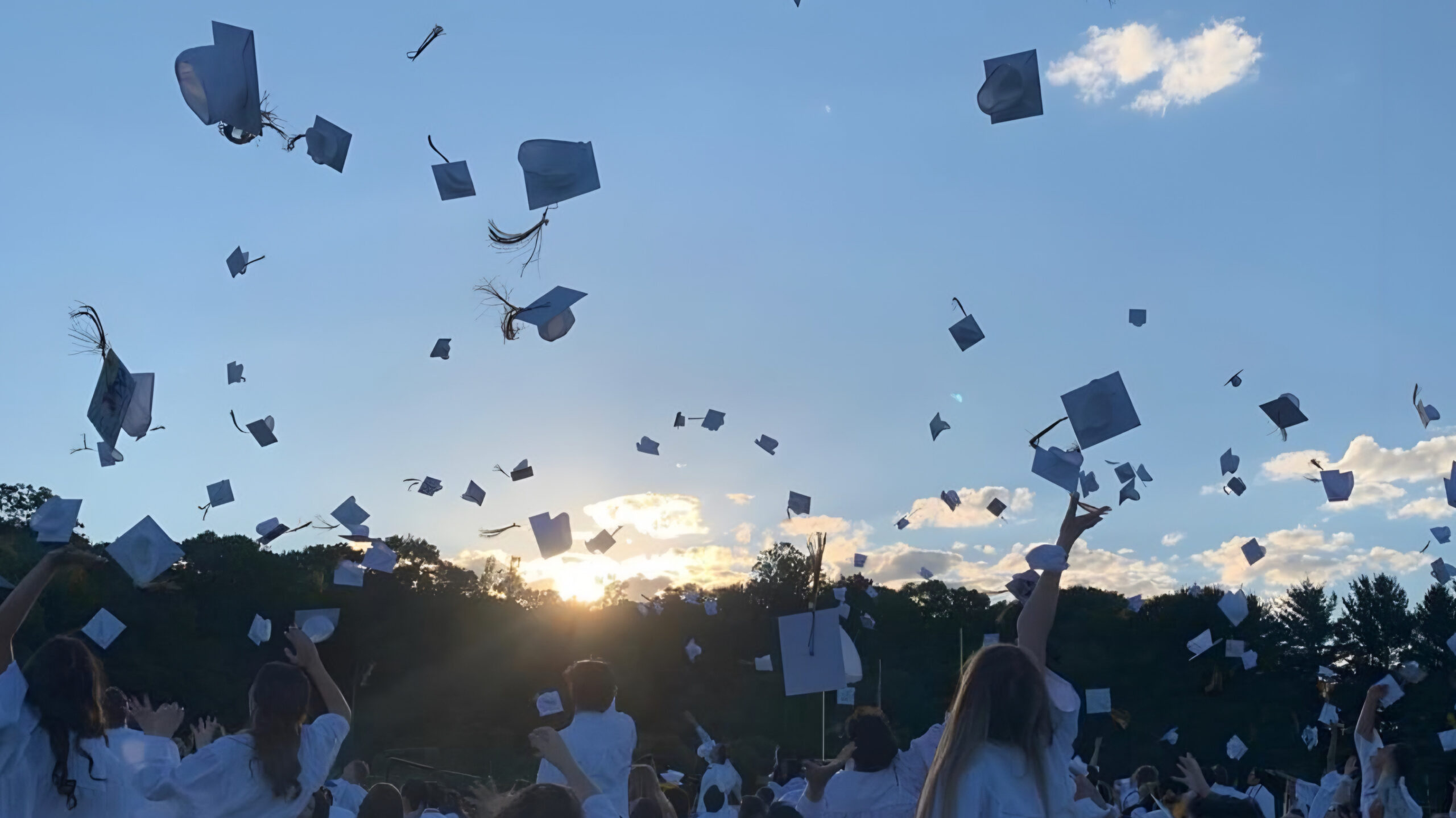 Graduation caps being tossed in the air in celebration