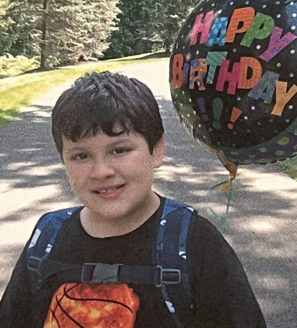 Michael holding a Happy Birthday balloon.