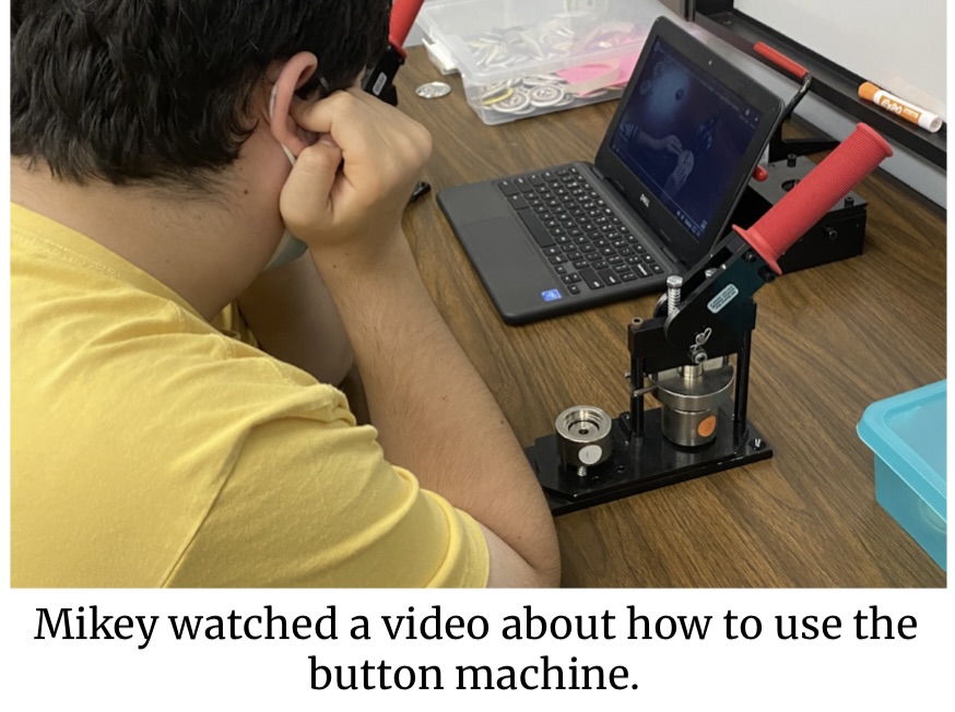 Michael watching a video to learn how to use the button making machine