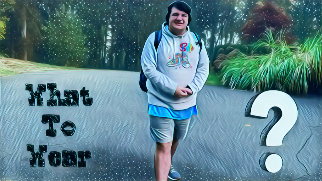 Mikey on our driveway on a cold day, wearing shorts, a tee shirt and a hoodie. He looks happy.