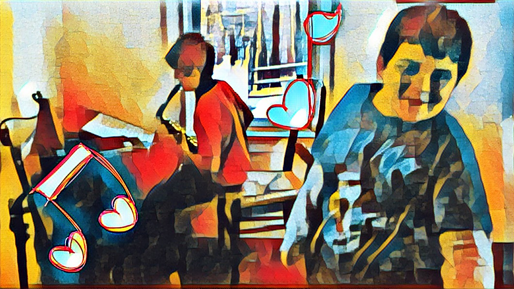 Will sitting at his music stand, playing saxophone with his metronome going. Mikey smiling as he listens in the foreground.
