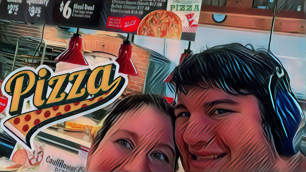 Erica and Mikey posing in front of the pizza ovens and signs at Stew Leonard's.