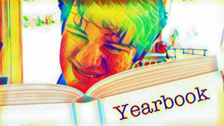 stylized photo of Mikey looking at his 'yearbook' (a book sticker labeled yearbook) smiling broadly
