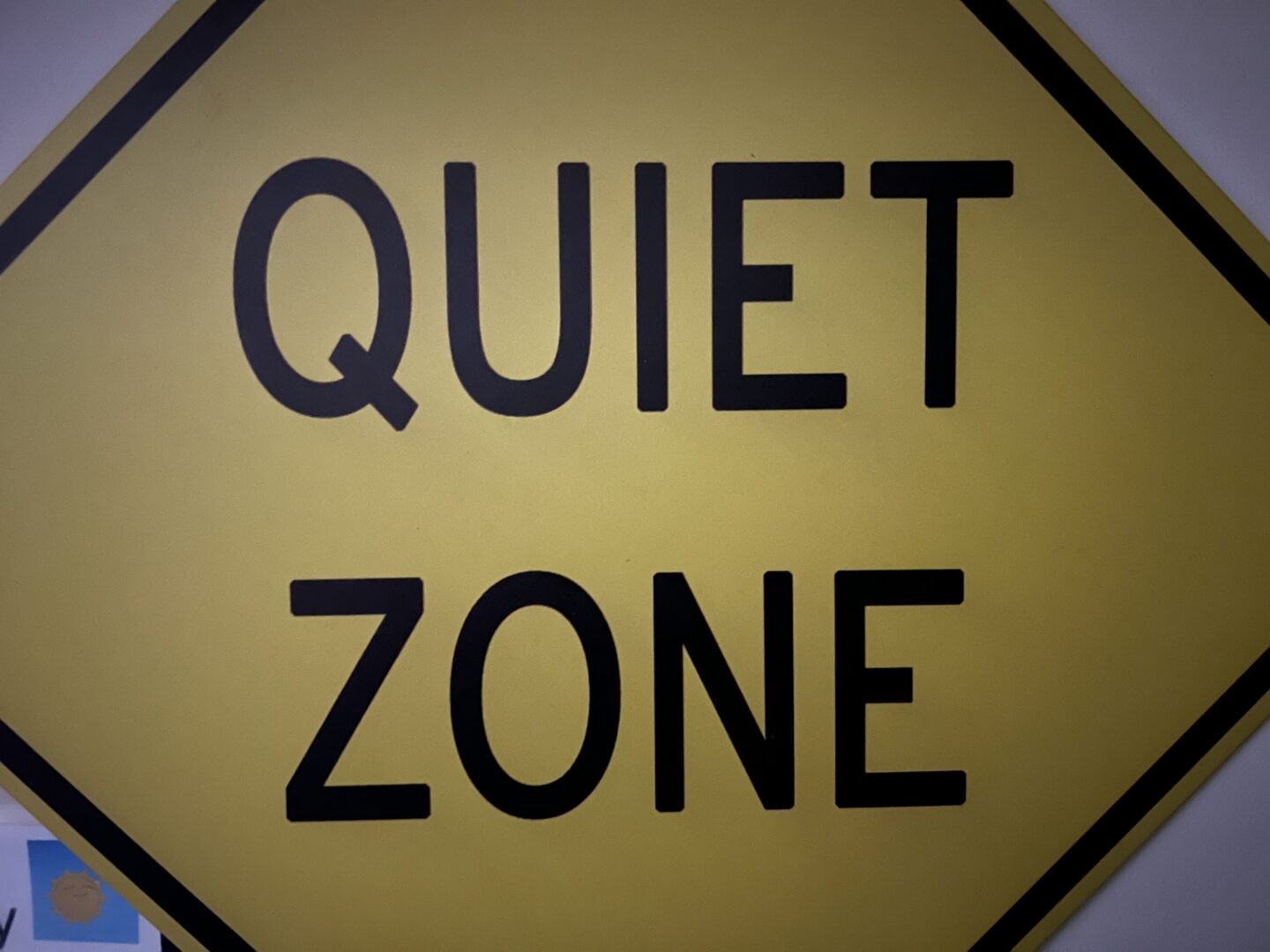 Yellow diamond road sign reading QUIET ZONE