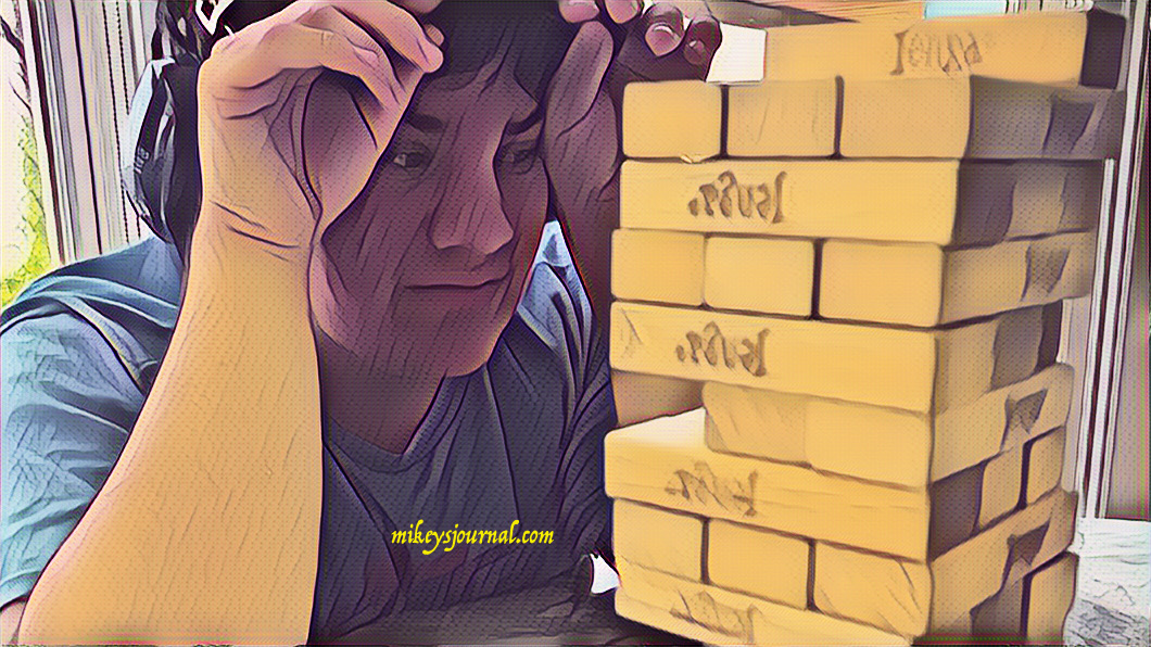 stylized photo of Mikey, head in hands, deciding which Jenga piece to take next