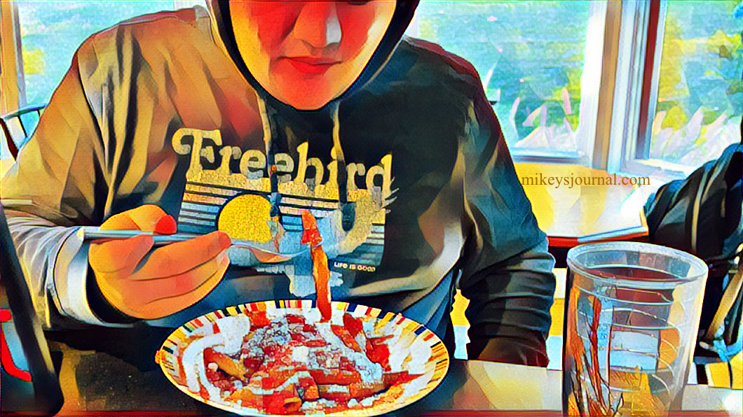 stylized photo of Mikey wearing his Freebird tee-shirt hoodie, eating his pasta, red sauce and parmesan cheese