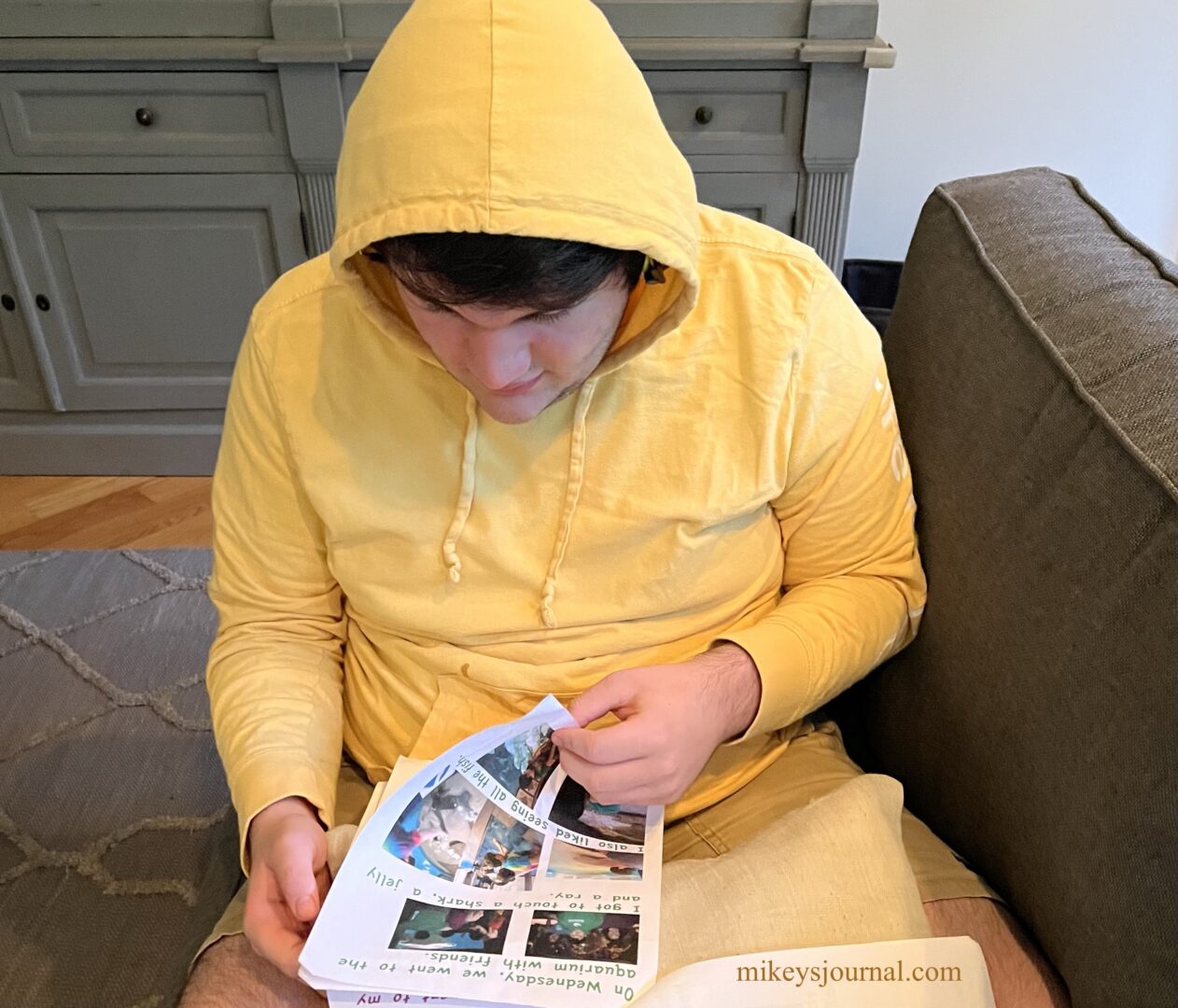 Michael flipping the page after reading the Wednesday page about going to the aquarium with friends.