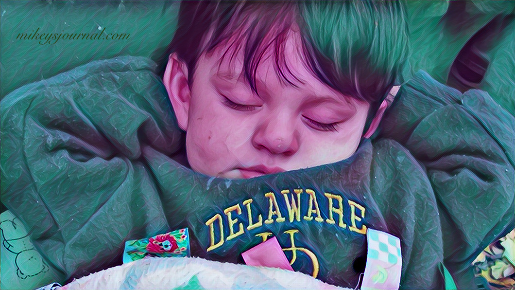 photo of baby mikey sleeping with his hands behind his head.
