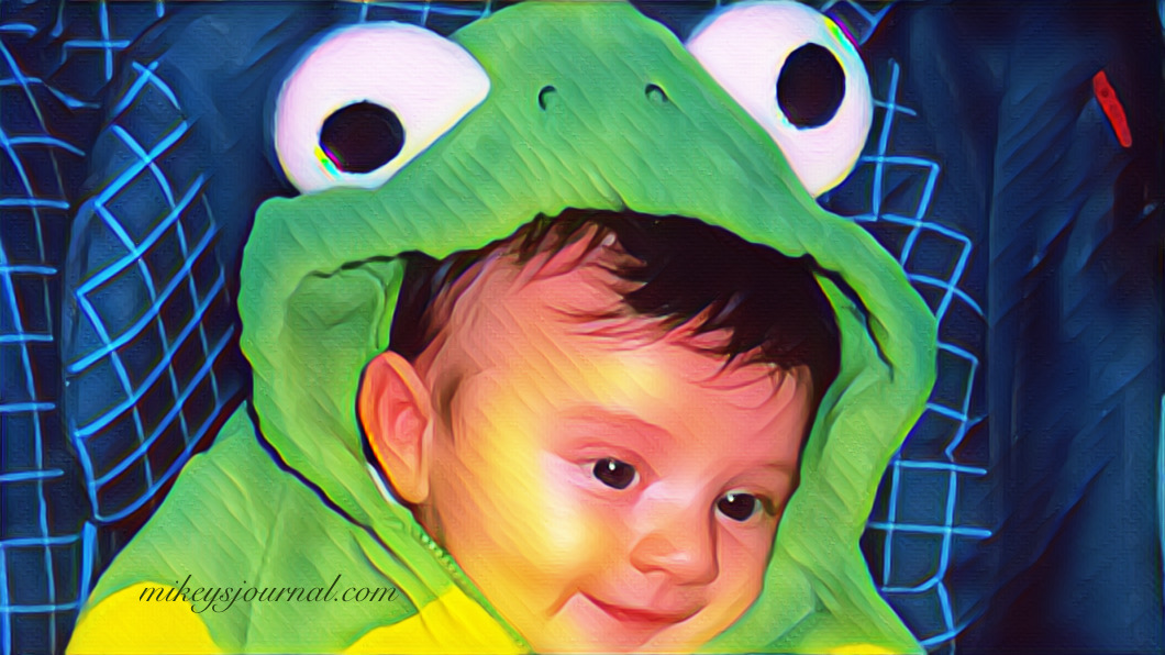 baby mikey in a fuzzy frog costume in his stroller