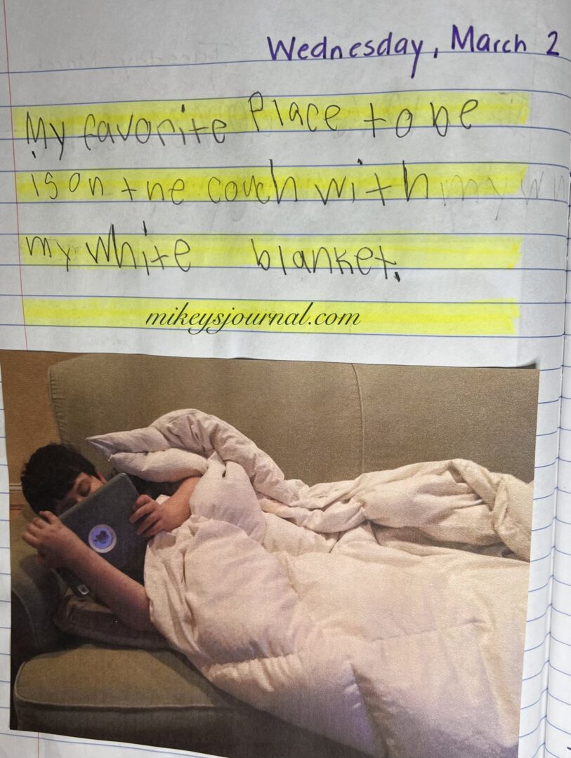 journal entry from March 2: “My favorite place other than be is on the couch with my white blanket.” Photo of Mikey laying on his side on the couch, covered in his white blanket, holding his ipad watching something.