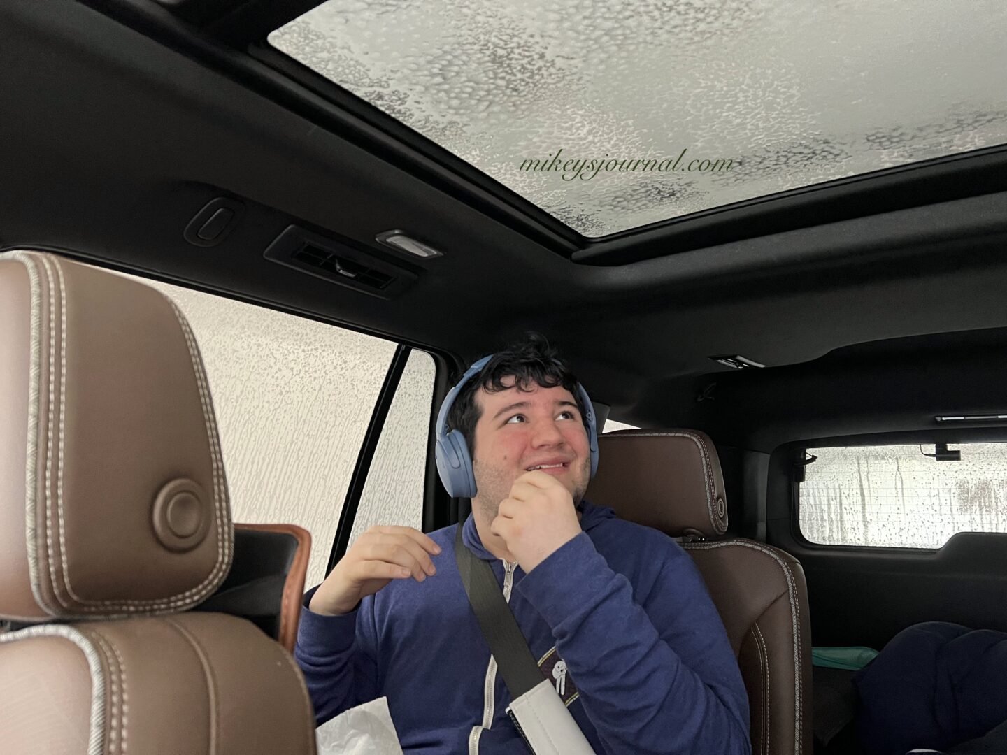 Mikey watching the soap and water foam up the windows of the car with a smile.