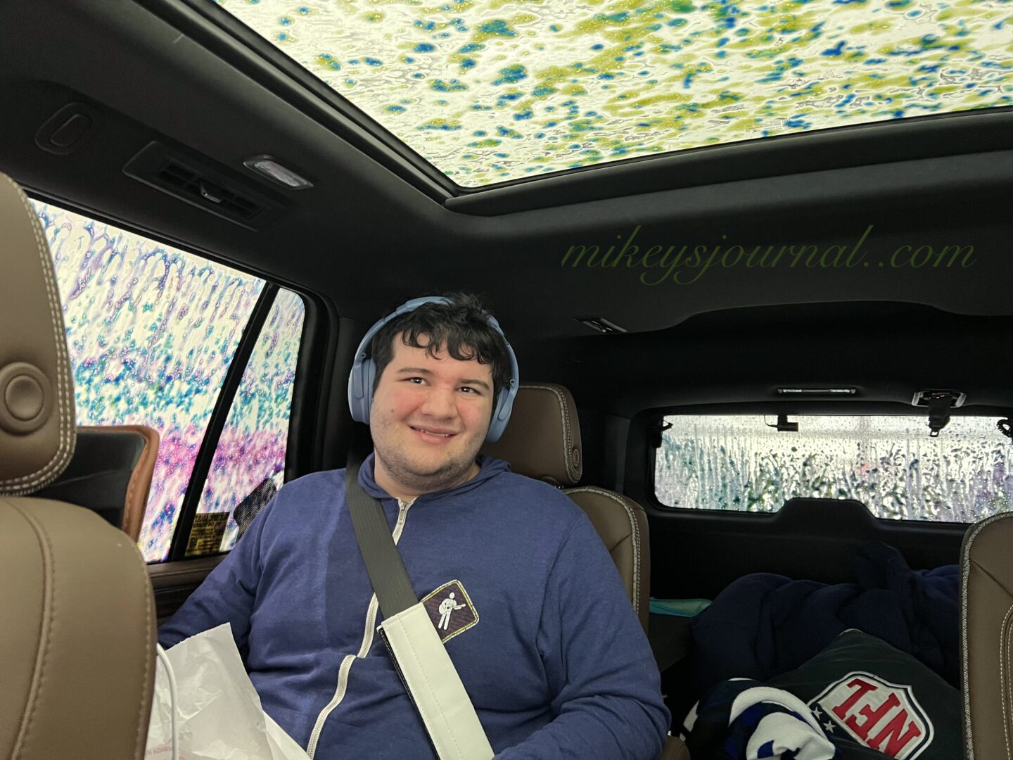 Mikey in the car surrounded by the tricolor foam in the car wash