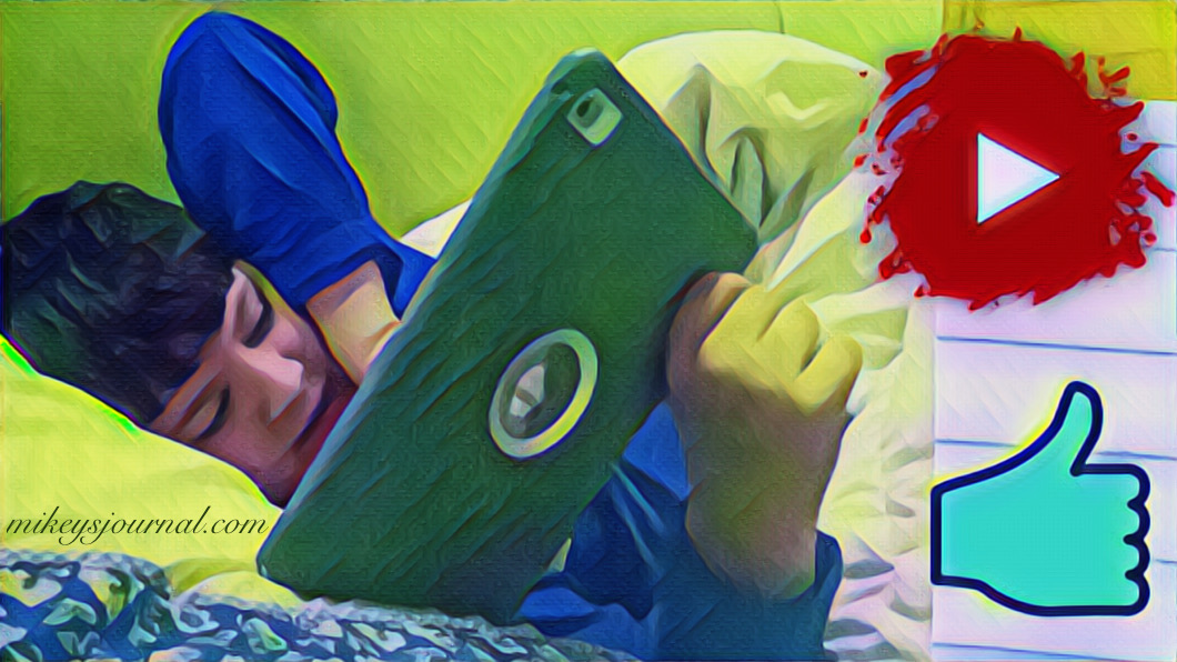 21EC728A-A2D2-4C97-9E6C-0637226F3FD4 mikey, laying on the couch, face in his iPad, YouTube symbol and like symbol.