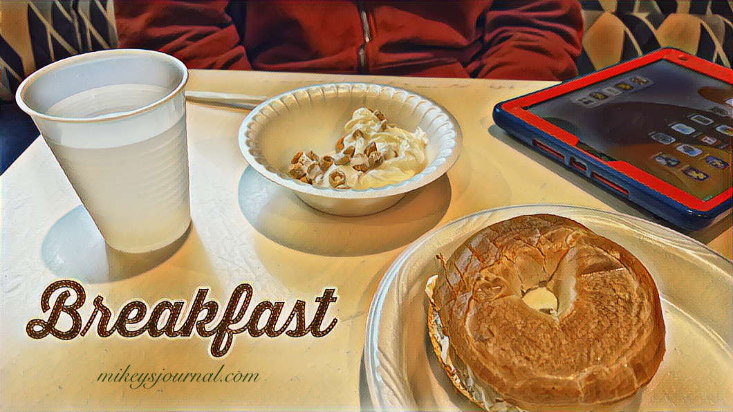 Mikey’s hotel breakfast (yogurt with cheerios and a bagel with cream cheese), his play ipad is also on the table.