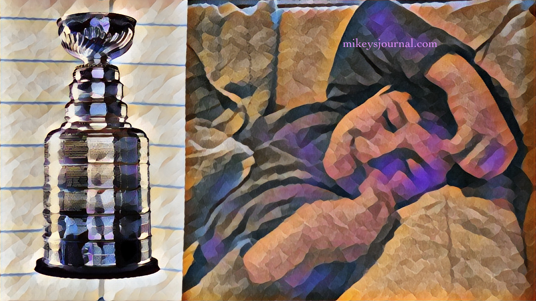 stylized photo of Mikey smiling under his blanket on the couch and with a sticker of the stanley cup added for fun.