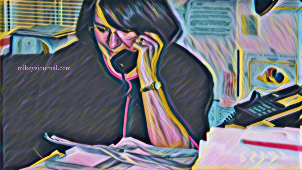 My mom sitting at her desk on the phone surrounded by papers