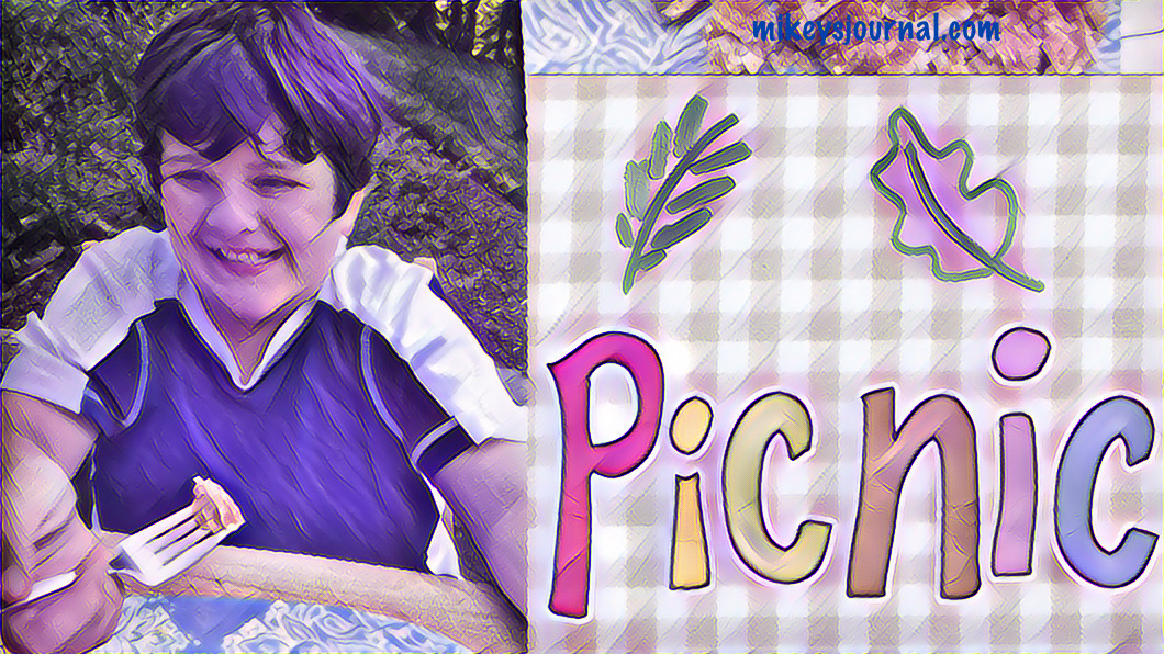 Mikey smiling with some chicken tender on his fork, eating outside at our picnic table. Title picnic with painted leaves.