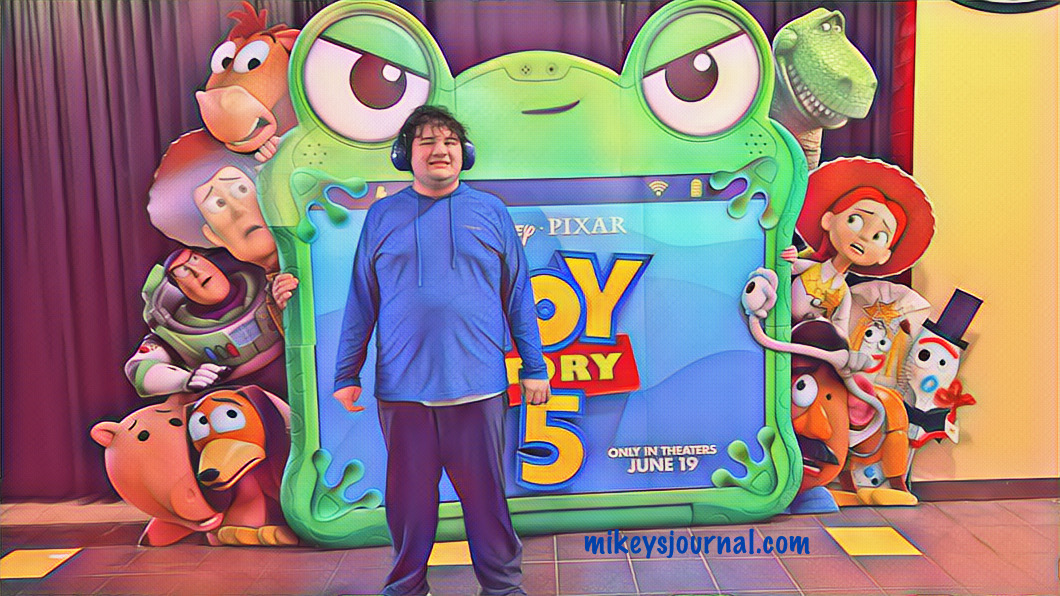 Mikey posing in front of the Toy Story 5 cutout at the movie theater