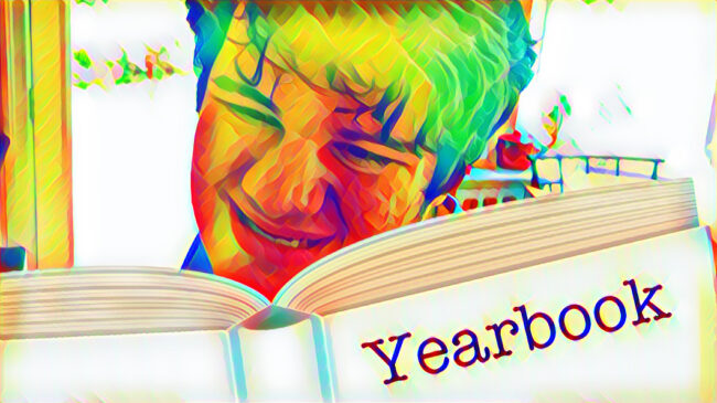 stylized photo of Mikey looking at his 'yearbook' (a book sticker labeled yearbook) smiling broadly